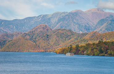Lake Chuzenji and mountain range during autumn season on bright sunny day, Nikko, Japan.