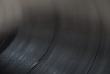 A close look at the music track on a vinyl record, selective focus, macro.
