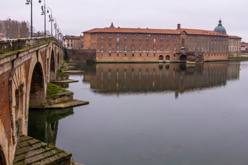 The Toulouse Bridge (Pont Neuf) in winter, with perfect reflections of the arches on the river
