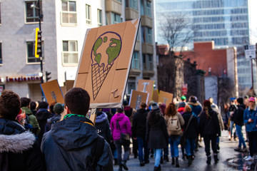 Activists unite at climate change march. A close up view of a homemade cardboard sign showing...