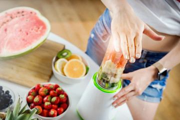 Hands of woman preparing smoothie fruit drink