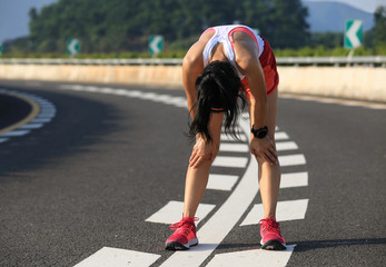 Healthy lifestyle fitness woman runner have a rest on highway road