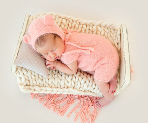 newborn baby girl sleeping in a little bed