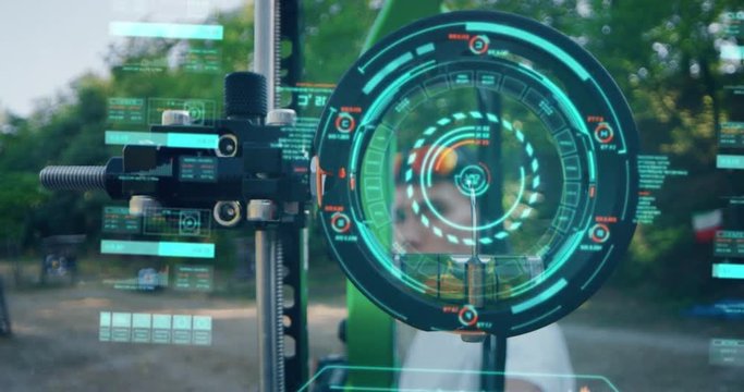 Slow motion viewfinder compound close up of young man with professional equipment is using futuristic latest innovative technology augmented reality holograms to practice an archery with a bow. 