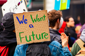 Ecological activist holds homemade sign. A cardboard sign is viewed close-up saying we want a...