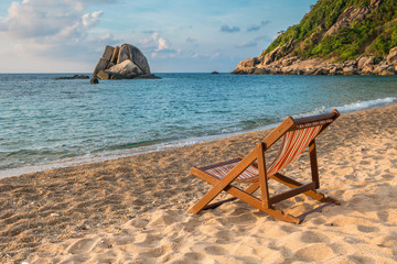 Tropical background from Phangan island in Thailand with beach chair on the sand  with blue sky and palm trees. Travel Vacation concept