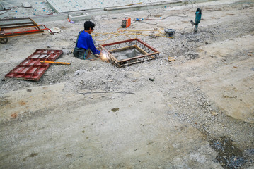 Construction workers are making pipes on the road.