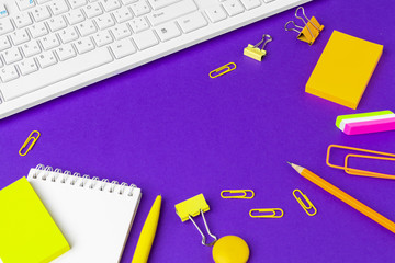 Composition of office lifestyle items on  purple background, computer keyboard office supplies on desk in office