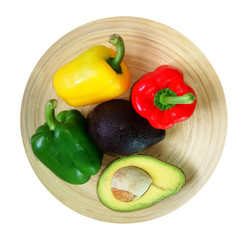 Fresh fruit and vegetables in a wooden dish placed on white background
