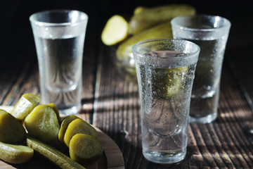 Three shots with vodka and pickled cucumbers