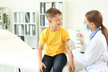 Fototapeta premium Doctor vaccinating little boy in clinic