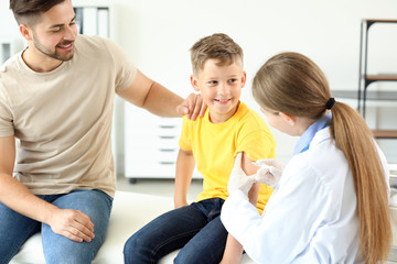 Doctor vaccinating little boy in clinic