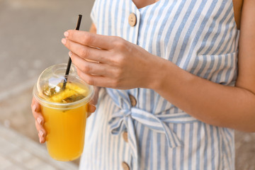 Woman with cup of tasty pineapple juice outdoors, closeup