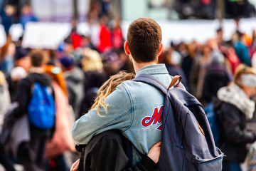 People unite against global warming. A young millennial couple are seen cuddling from behind, as...
