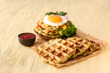 Tasty squash waffles with sauce on wooden table