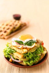 Plate with tasty squash waffles and fried egg on wooden table