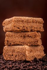 Brownie stack, closeup chocolate cake on coffee beans background - brown background