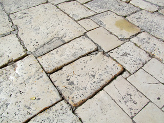 Old gray stone pavement in Split, Croatia. Image of ancient rough street cover is realistic background.