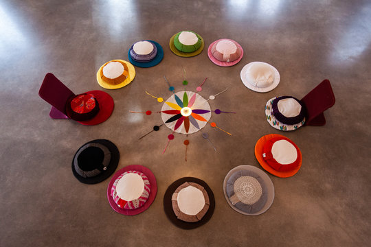 Sacred items form circle in prayer room. A high angled view on the twelve colors of the Native American wheel symbology, laid on the floor inside a religious hall, ready for devotees to worship.