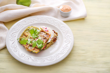 Plate with tasty squash waffles and fried egg on wooden table