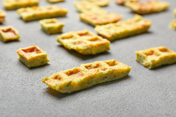 Pieces of squash waffles on grey background