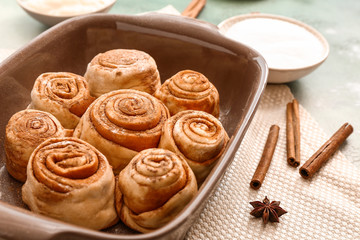 Baking tray with tasty cinnamon buns on table