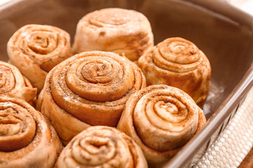Tasty cinnamon buns in baking tray, closeup