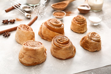 Tasty cinnamon buns on table