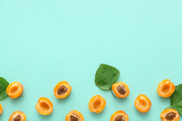Tasty cut apricots on color background