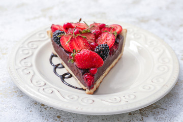 Piece of tasty chocolate strawberry cake on plate