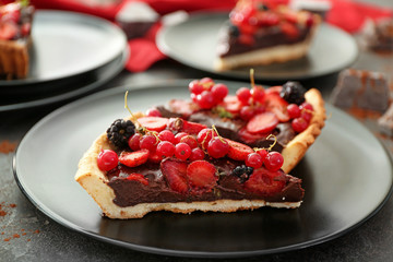 Pieces of tasty chocolate strawberry cake on plate, closeup