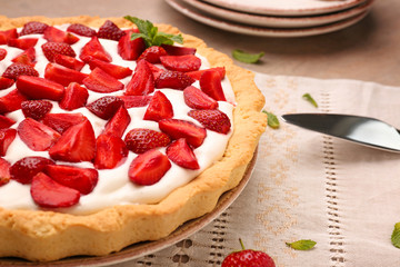 Tasty strawberry cake on table