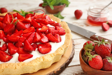 Tasty strawberry cake on white wooden table