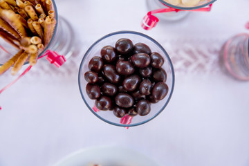 Dark chocolate balls with almond heart. in a glass jar .In a round black chocolate glass . Dark chocolate candy balls in a glass bowl on white background, isolated .