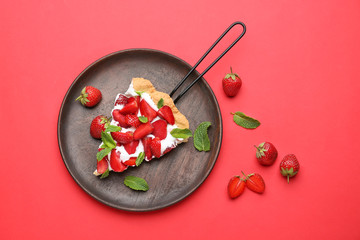 Plate with piece of tasty strawberry cake on color background