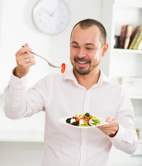 Smiling man looking at greek salad