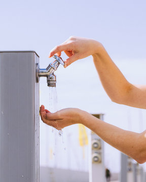 Woman drinking water from street tap