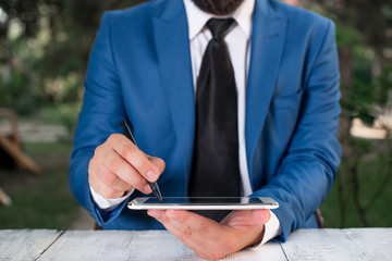 Businessman pointing with pen in empty copy space.