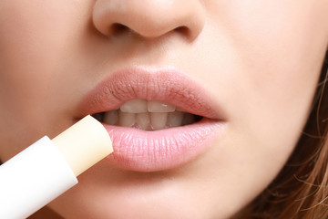 Naklejka premium Beautiful young woman applying lipstick, closeup
