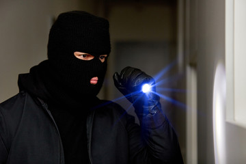 Einbrecher oder Dieb nachts mit Taschenlampe