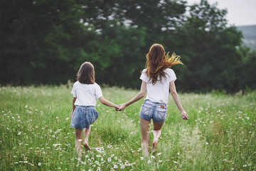Fototapeta premium mother and daughter running in the park