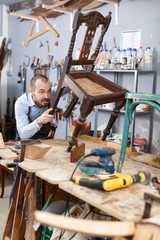 Carpenter repairing antique chair