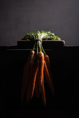 Bunch of carrots hanging on the side of the table