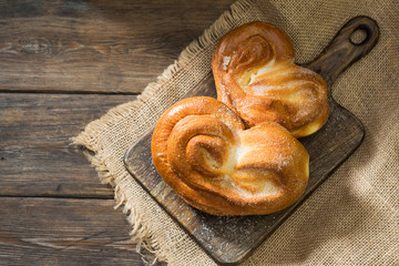Bun sprinkled with sugar. Sweet pastries. Rustic style