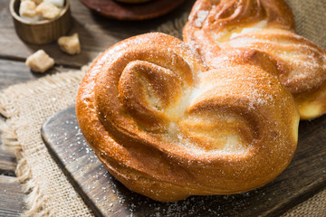 Bun sprinkled with sugar. Sweet pastries. Rustic style