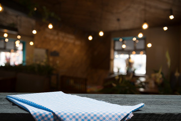 Empty wood table top on blur light gold bokeh of cafe restaurant in dark background
