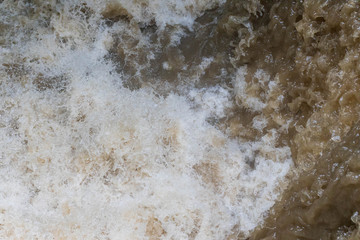 Overhead view of fast flowing brown water in flooding event