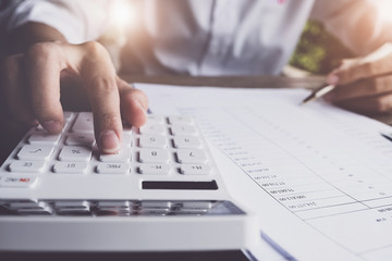 Customers use pens and calculators to calculate home purchase loans according to loan documents received from the bank. real estate concept.