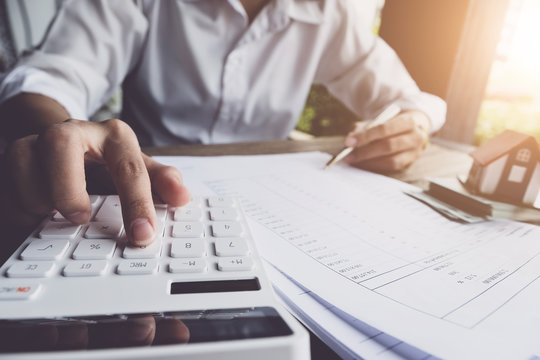 Customers use pens and calculators to calculate home purchase loans according to loan documents received from the bank. real estate concept.