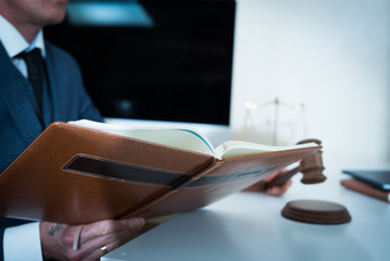 Naklejka premium Lawyer businessman working or reading lawbook in office workplace for consultant lawyer concept.